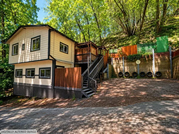a front view of a house with a tree