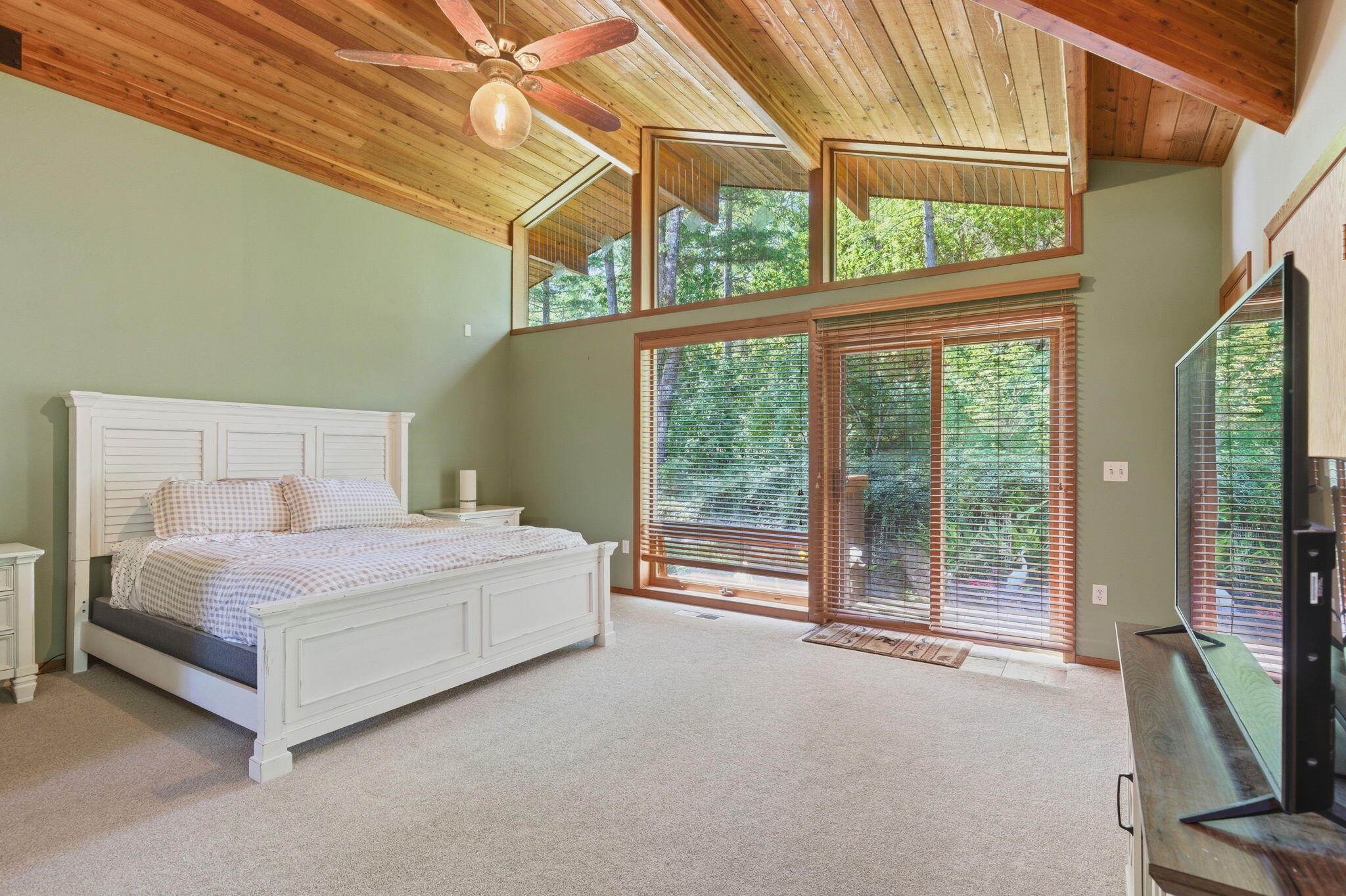 856 Greentree Loop Grants Pass, OR 97527 - Photo 24 of 62 a spacious bedroom with a bed and a flat tv screen next to a large window