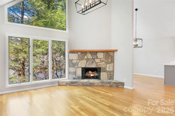 a big room with wooden floor fireplace and windows