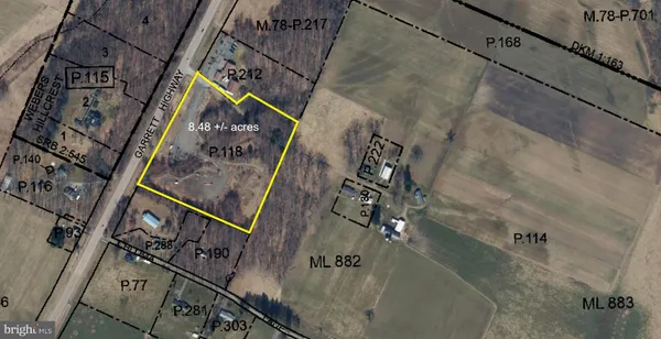 a view of a dry yard with trees in the background