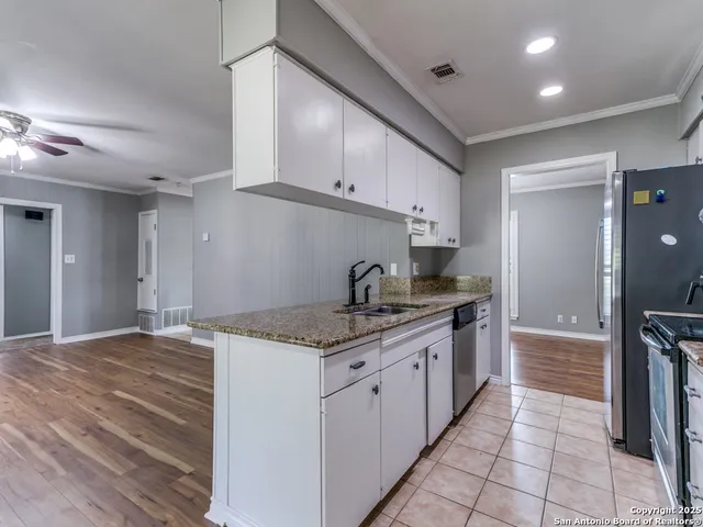 a kitchen with granite countertop a sink and cabinets