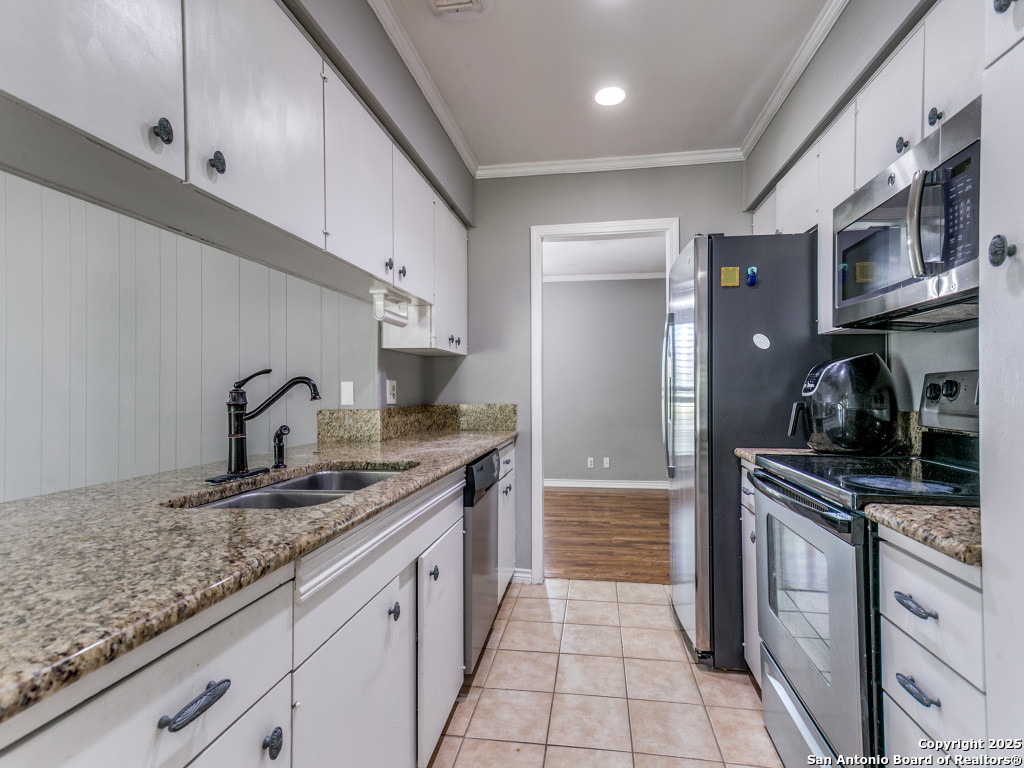 249 Ralston Drive Converse, TX 78109 - Photo 13 of 25 a kitchen with granite countertop stainless steel appliances a sink stove top oven and cabinets