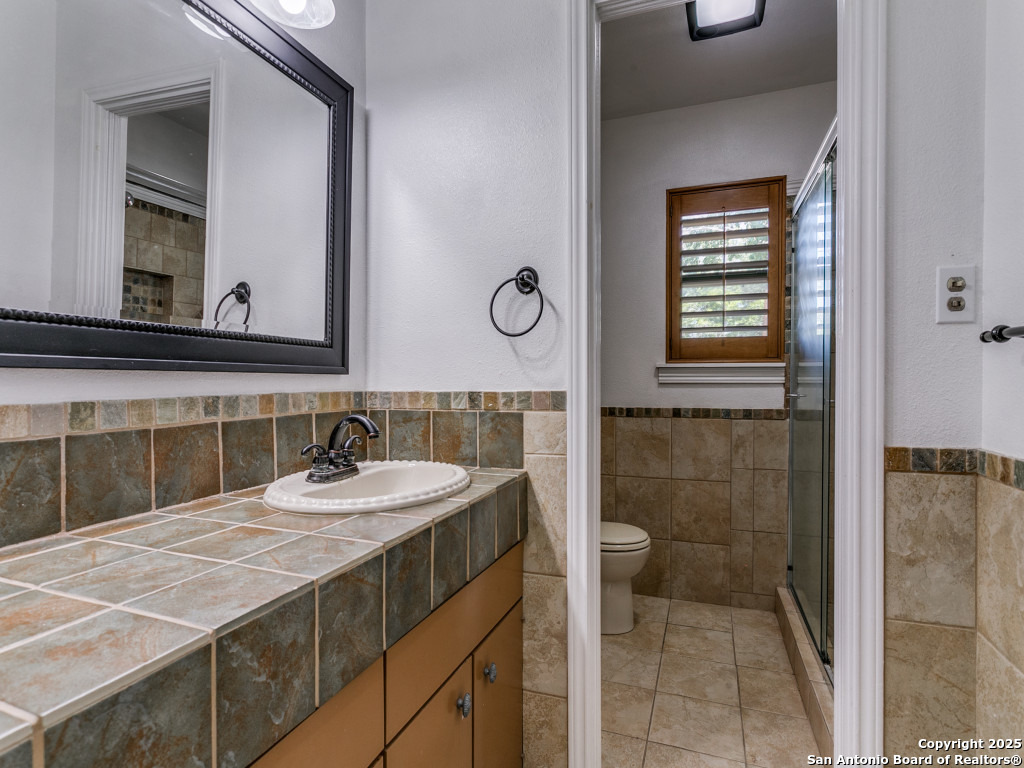 249 Ralston Drive Converse, TX 78109 - Photo 18 of 25 a bathroom with a sink a toilet and a mirror