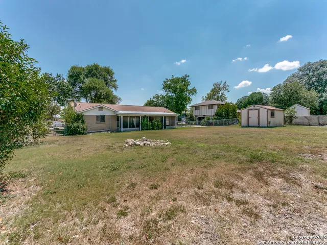 a front view of house with yard and trees in the background