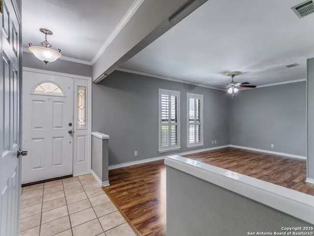 a view of an empty room and window and a kitchen