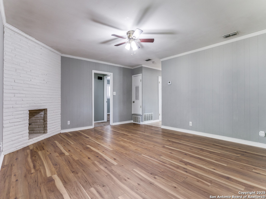 249 Ralston Drive Converse, TX 78109 - Photo 8 of 25 a view of an empty room with wooden floor fireplace and a window