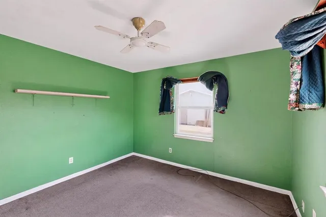 a view of a room that has a bed and a chandelier fan