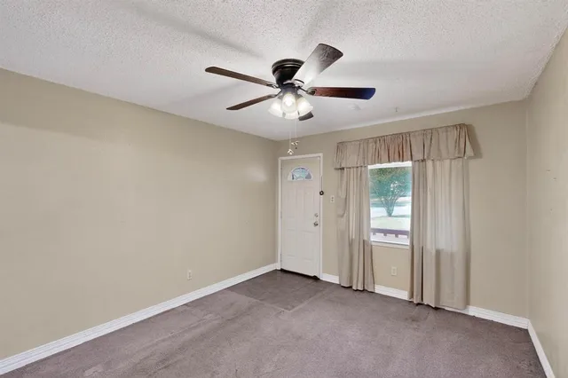 an empty room with closet and a chandelier fan