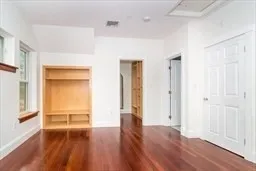 a view of a room with wooden floor and a window