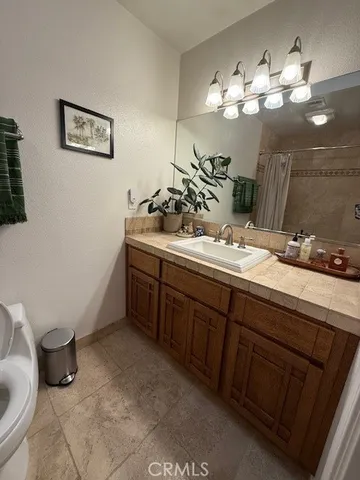 a bathroom with a sink a toilet and a mirror