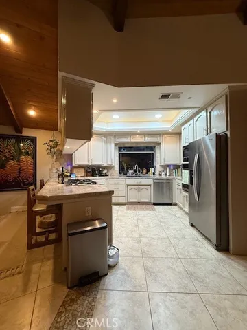 a kitchen with stainless steel appliances kitchen island granite countertop a refrigerator and a stove top oven