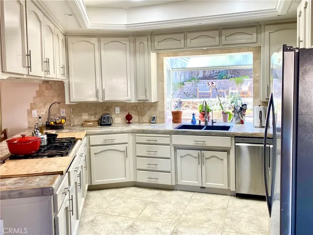 a kitchen with stainless steel appliances granite countertop a stove a sink and a refrigerator