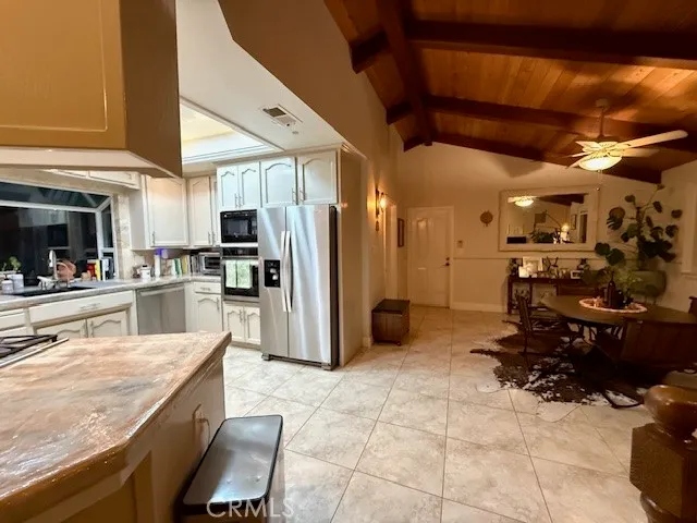 a kitchen with stainless steel appliances kitchen island granite countertop a refrigerator and microwave