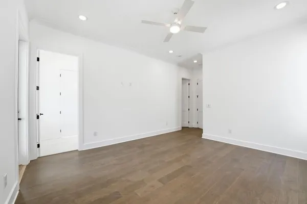 an empty room with an entryway and fan