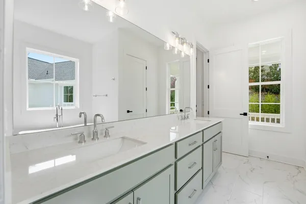 a bathroom with double vanity sinks and a mirror