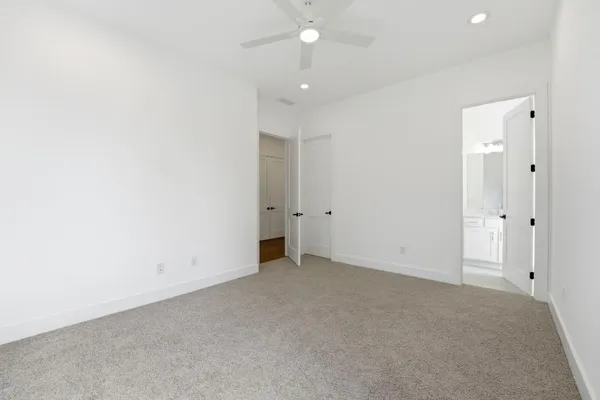 an empty room with an entryway and fan