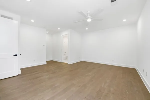 an empty room with an entryway and fan