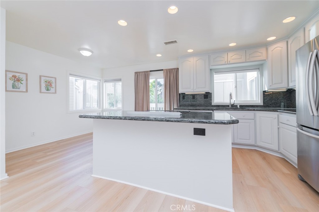 34028 Selva Road, Unit 77 Dana Point, CA 92629 - Photo 11 of 39 a kitchen with granite countertop white cabinets and white appliances