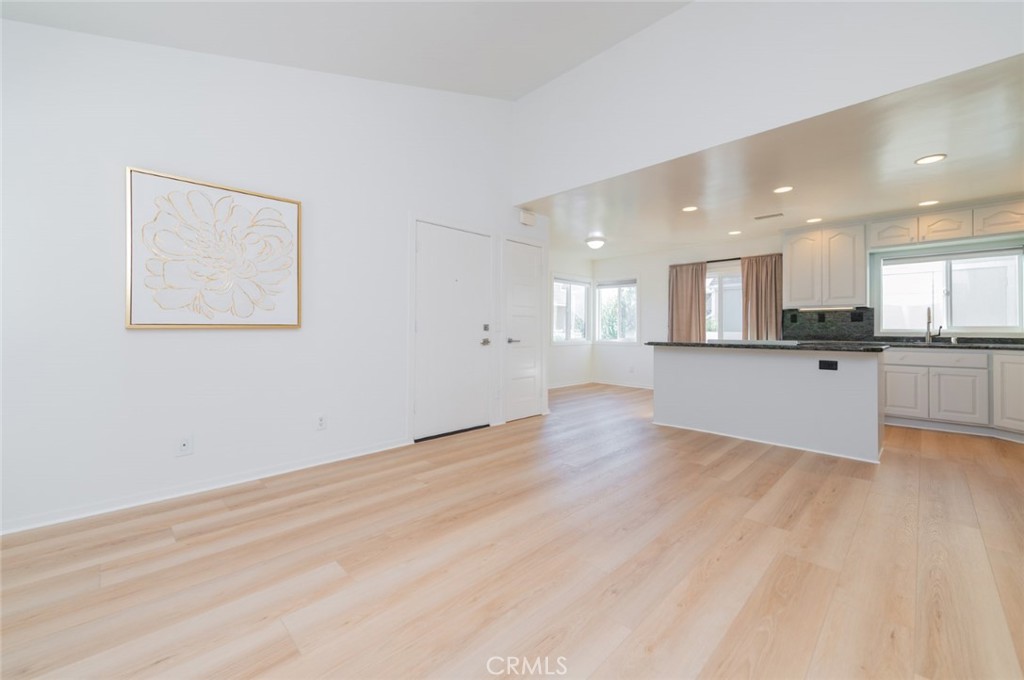 34028 Selva Road, Unit 77 Dana Point, CA 92629 - Photo 6 of 39 a view of an empty room and kitchen view with wooden floor