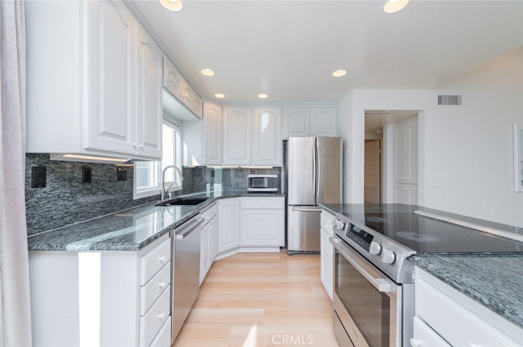 34028 Selva Road, Unit 77 Dana Point, CA 92629 - Photo 8 of 39 a kitchen with stainless steel appliances granite countertop a sink refrigerator and cabinets