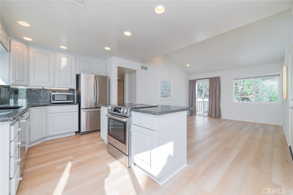 34028 Selva Road, Unit 77 Dana Point, CA 92629 - Photo 9 of 39 a kitchen with refrigerator cabinets and wooden floor