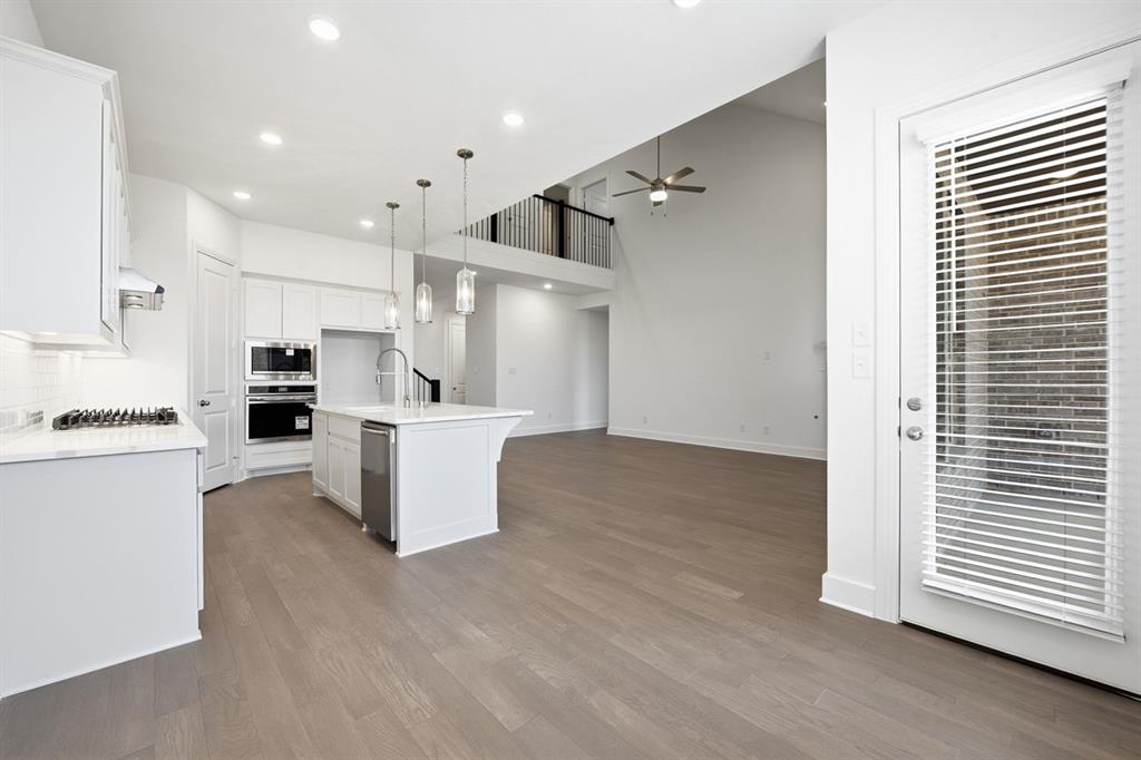4107 Windy Point Court Oak Point, TX 75068 - Photo 19 of 30 a view of kitchen with kitchen island white cabinets and stainless steel appliances