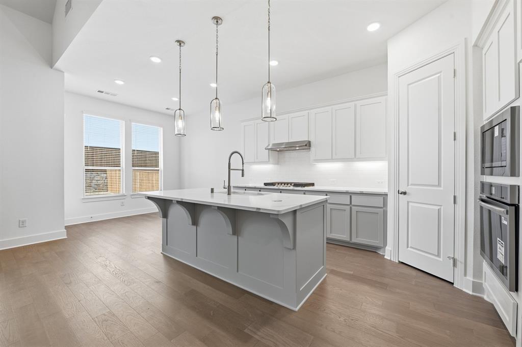 4107 Windy Point Court Oak Point, TX 75068 - Photo 2 of 30 a kitchen with kitchen island a sink stainless steel appliances and cabinets
