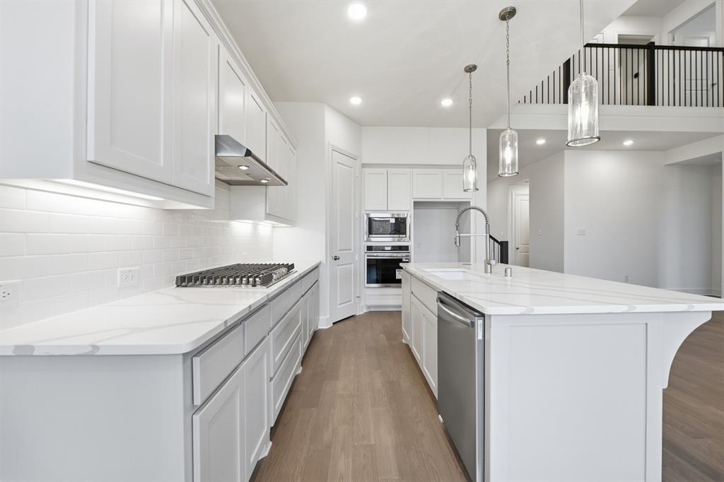 4107 Windy Point Court Oak Point, TX 75068 - Photo 3 of 30 a kitchen with a sink a stove oven and white cabinets