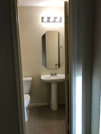 a bathroom with a sink and mirror with toilet