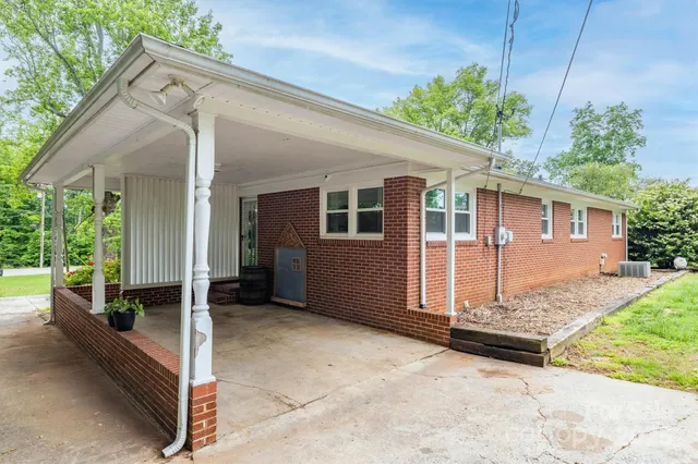 a view of backyard with large tree and wooden fence