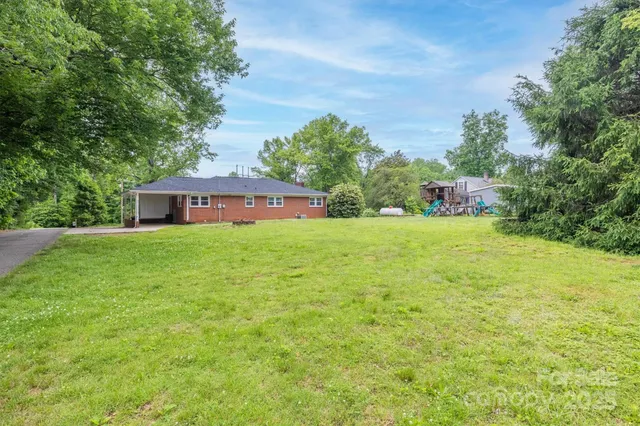 a view of a house with a yard and sitting area