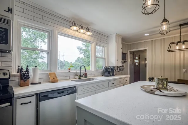 a kitchen with sink and large window