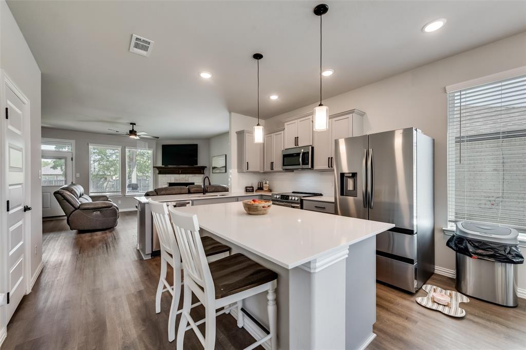 523 New Hope Street Terrell, TX 75160 - Photo 16 of 17 a kitchen with stainless steel appliances a refrigerator a stove a sink dishwasher a dining table and chairs with wooden floor