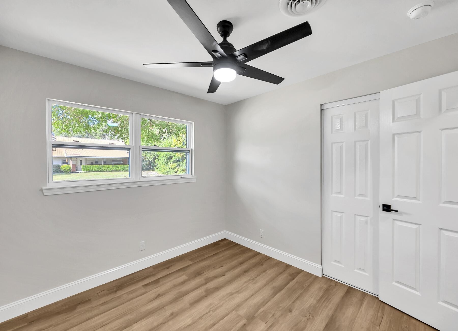 500 Ross Road Fort Walton Beach, FL 32547 - Photo 29 of 38 an empty room with wooden floor chandelier fan and windows
