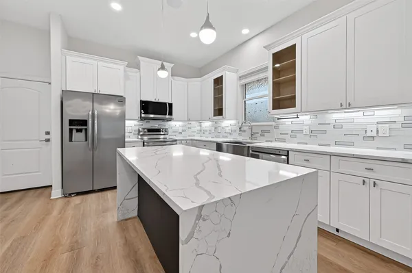 a kitchen with stainless steel appliances granite countertop a sink stove microwave and refrigerator