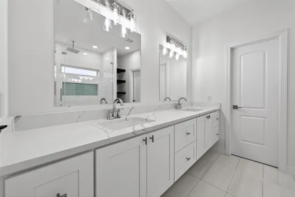 a bathroom with double sink and a mirror