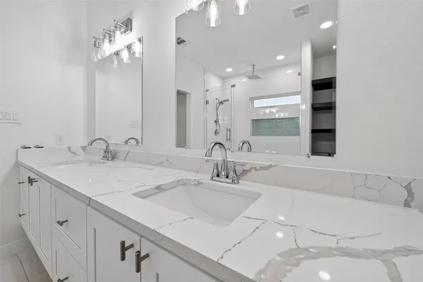 a bathroom with a double vanity sink and a mirror