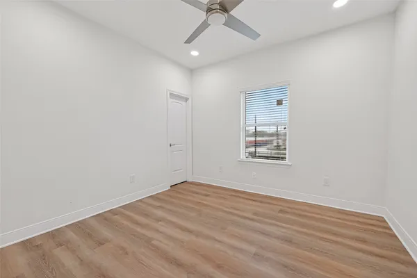an empty room with a ceiling fan and window