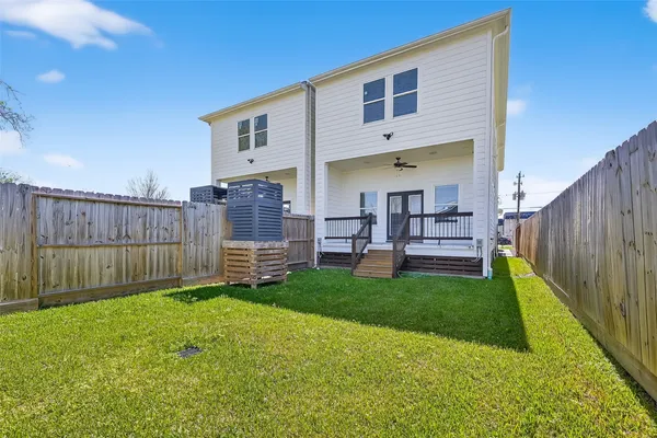 a view of a house with backyard and a fence
