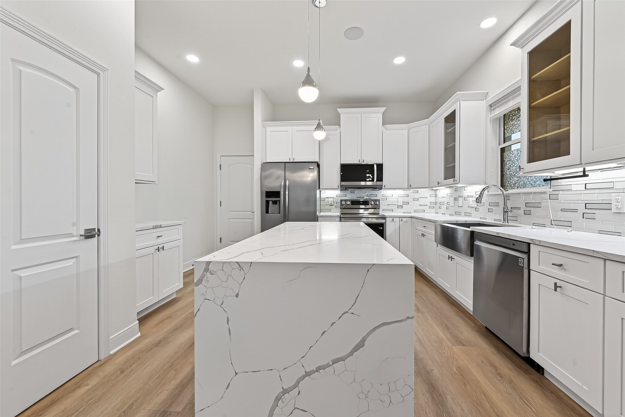 6630 Highrock Road Houston, TX 77092 - Photo 9 of 40 a kitchen that has a lot of white cabinets and stainless steel appliances