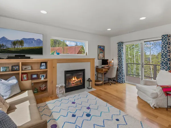 a living room with furniture a flat screen tv and a fireplace