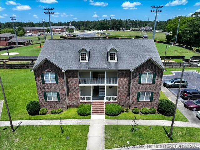 a front view of a house with a yard and green space