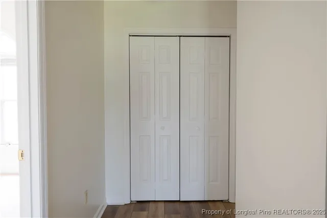 a view of a closet with wooden floor