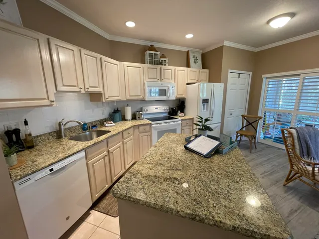 a kitchen with stainless steel appliances granite countertop a stove a sink and a white cabinets