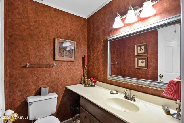 a bathroom with a toilet a sink and mirror