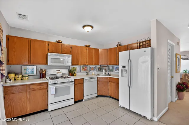 a kitchen with white cabinets sink and white appliances