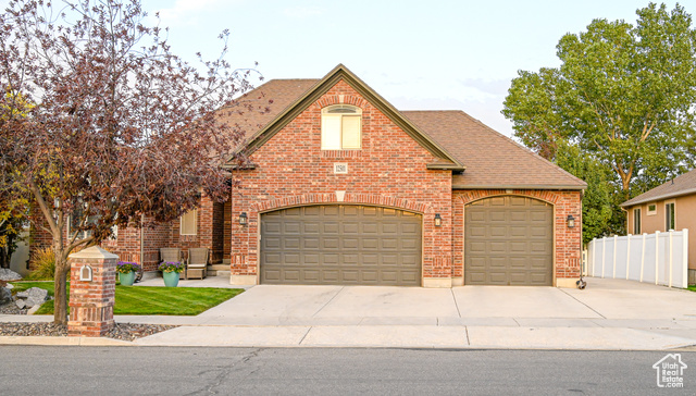 12501 South Huron Road Riverton, UT 84096 - Photo 1 of 1 View of front facade featuring brick siding, concrete driveway, a shingled roof, and a garage