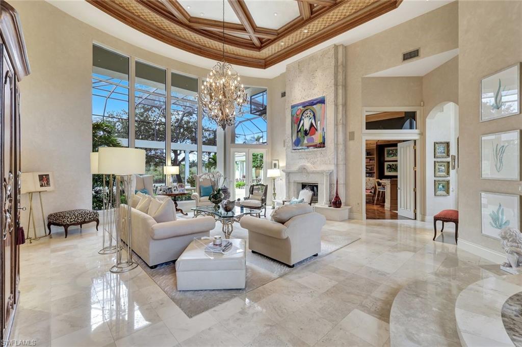 7261 Tilden Lane Naples, FL 34108 - Photo 11 of 46 a living room with furniture a fireplace and a chandelier