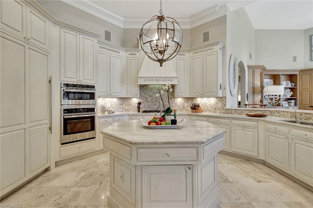 7261 Tilden Lane Naples, FL 34108 - Photo 19 of 46 a kitchen with kitchen island granite countertop stainless steel appliances a stove and cabinets