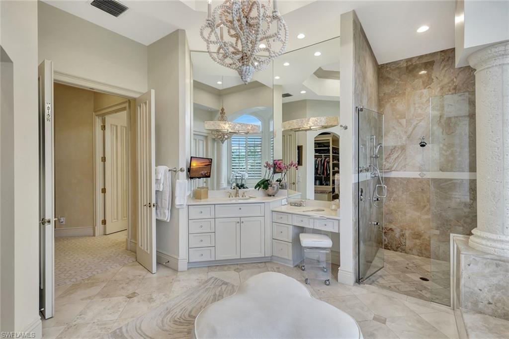 7261 Tilden Lane Naples, FL 34108 - Photo 31 of 46 a spacious bathroom with a shower sink and mirror